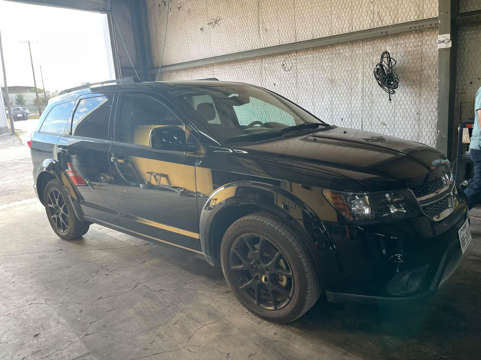 A black and yellow suv is parked in a garage.