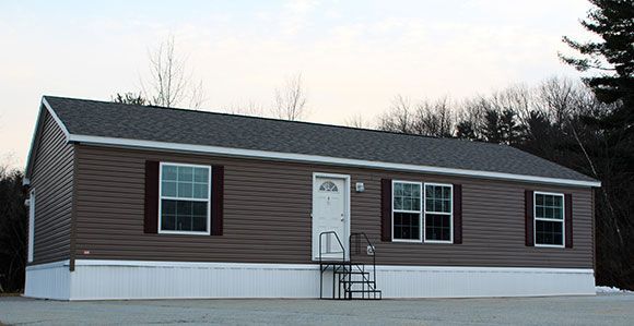 A mobile home with stairs leading up to the front door