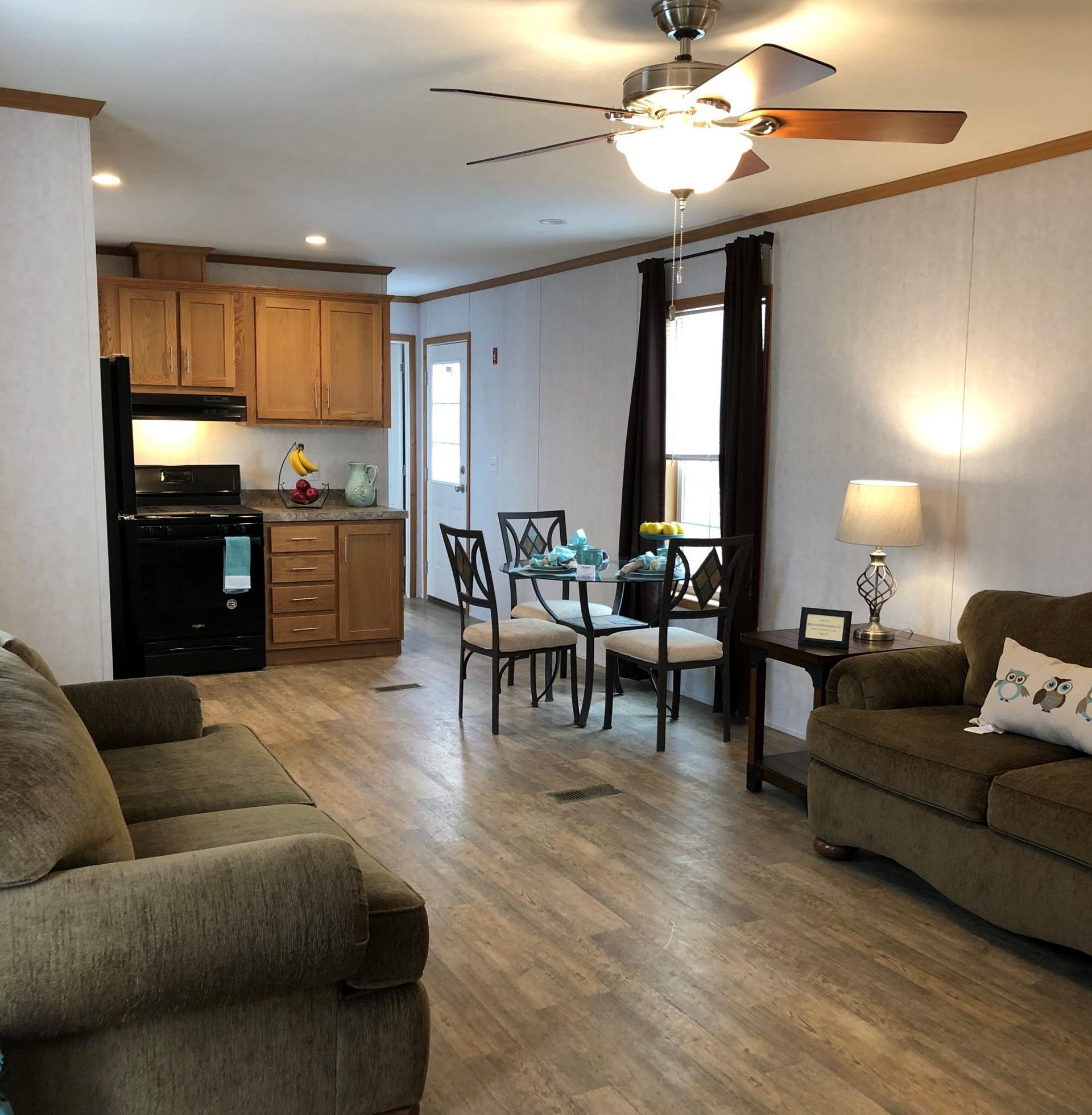 A living room with a couch and chairs and a ceiling fan