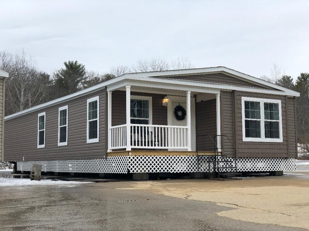 A mobile home with a porch and a wreath on the door.
