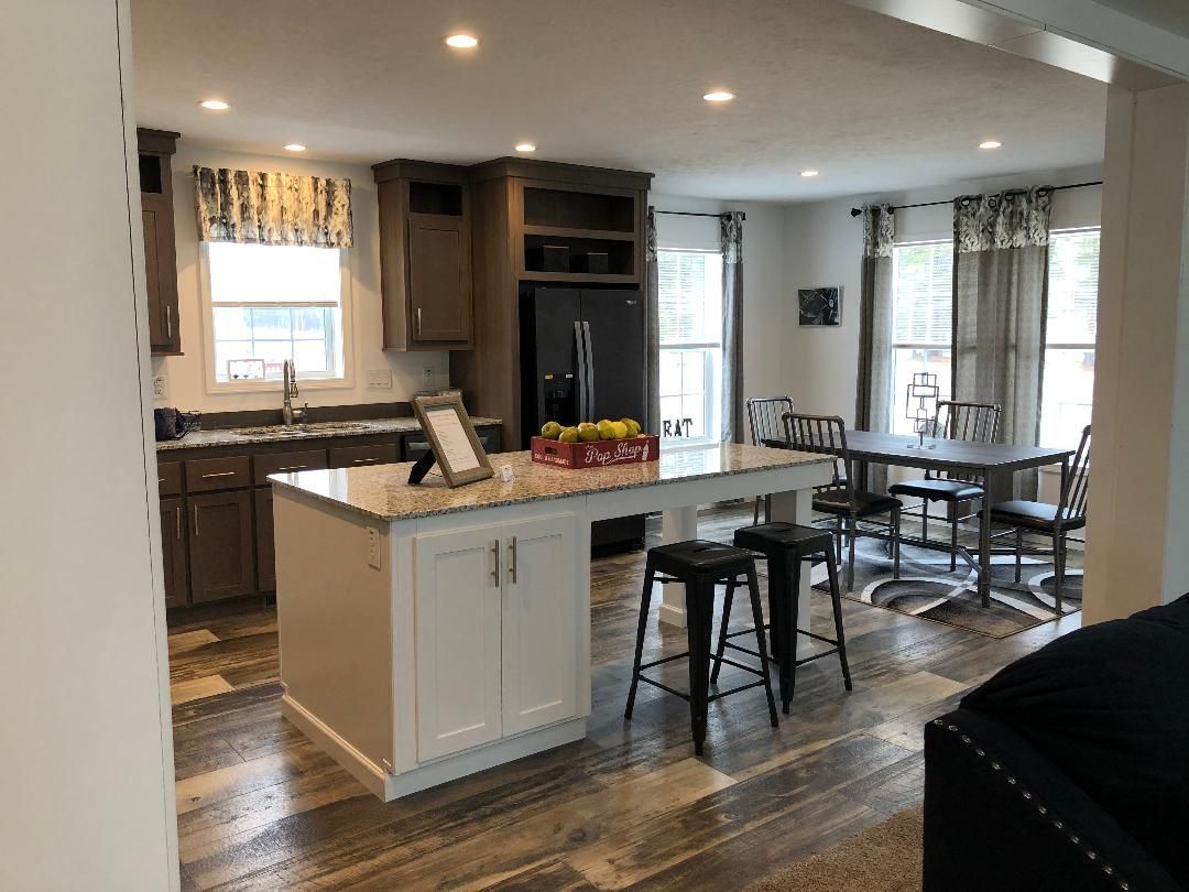 A kitchen with a large island and a table and chairs.