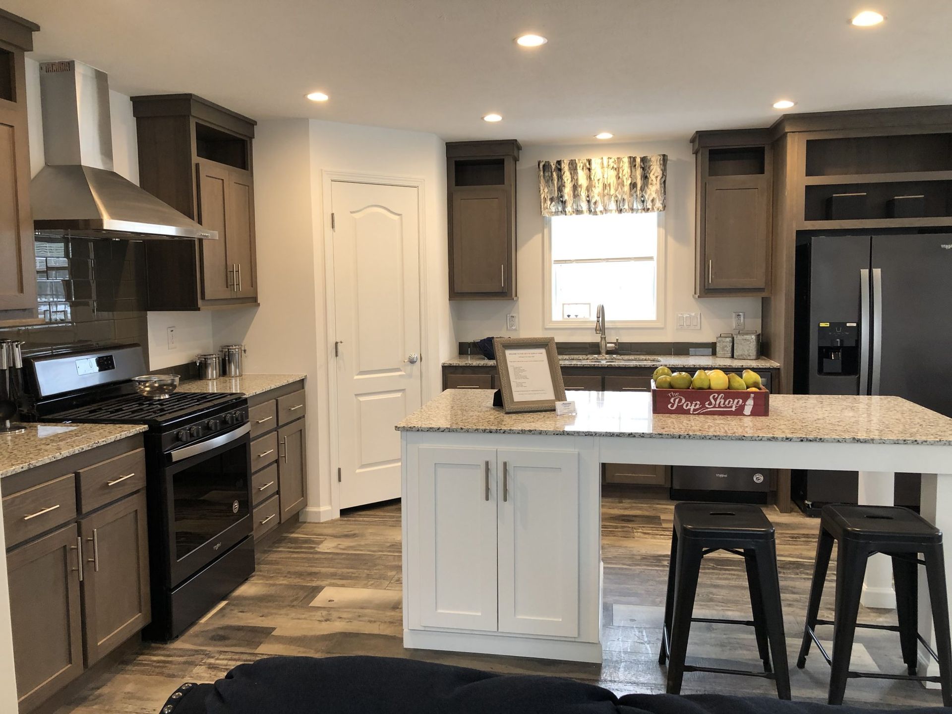 A kitchen in a mobile home with a large island in the middle.