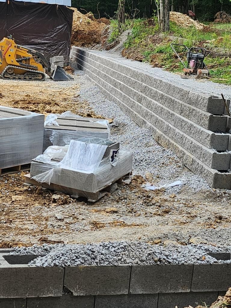 a concrete wall is being built on a construction site with a bulldozer in the background .