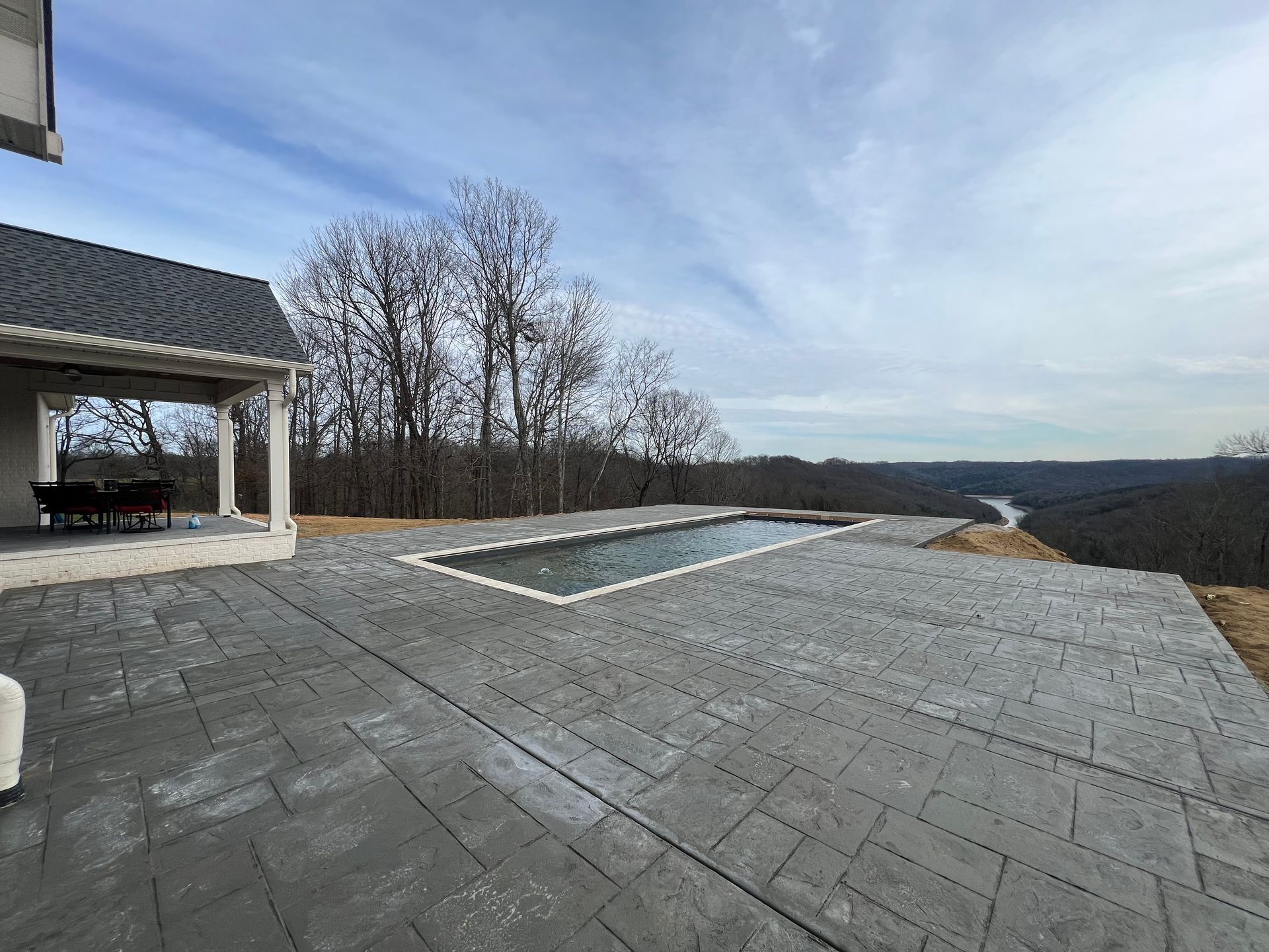 there is a large swimming pool in the backyard of a house.