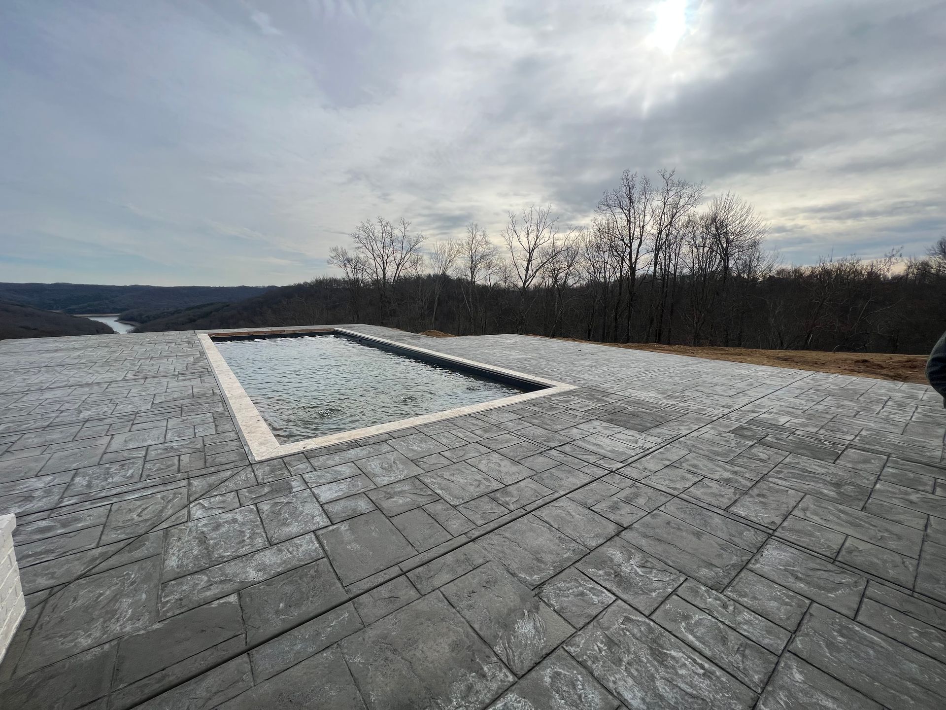 a large swimming pool is sitting on top of a concrete patio.