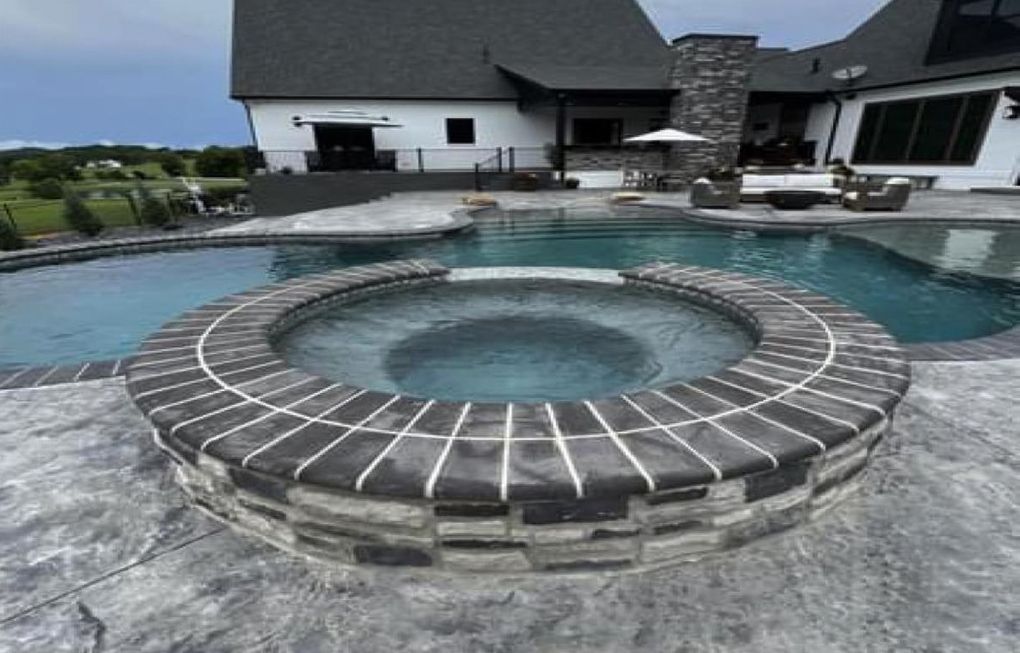 a large swimming pool with a hot tub in the middle of it