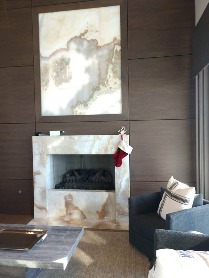 Fireplace with marble surround, dark wood paneling, and a Christmas stocking. Living room setting.