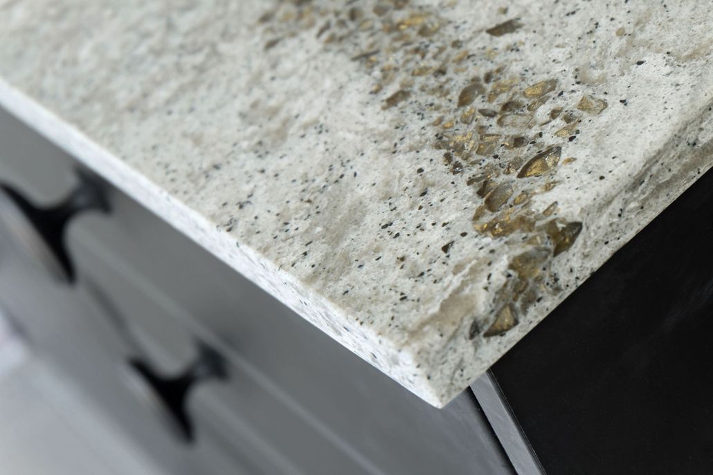 Close-up of a light-colored countertop with black cabinet below.