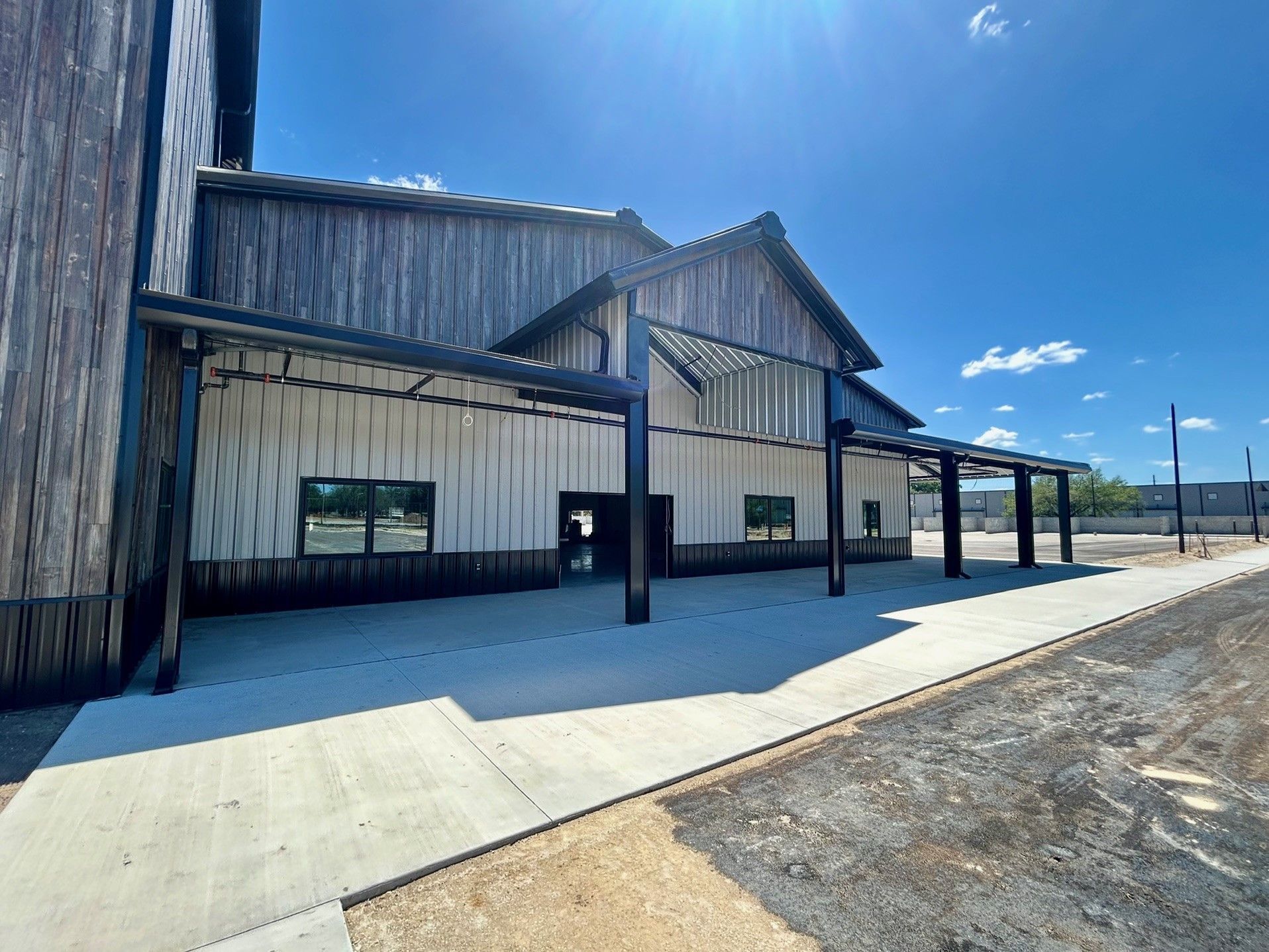 Rustic metal building with a covered walkway under a bright blue sky