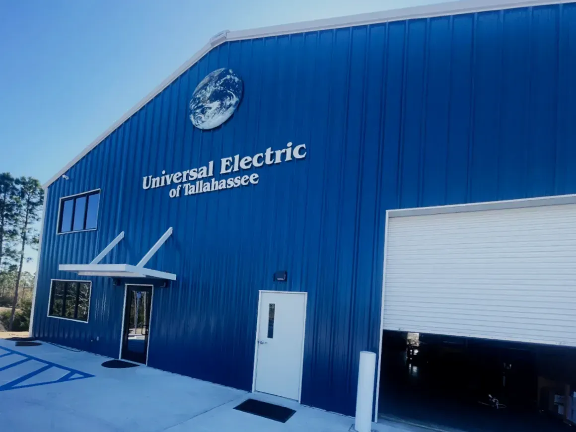 Blue Universal Electric of Tallahassee building with a garage door and entrance awning