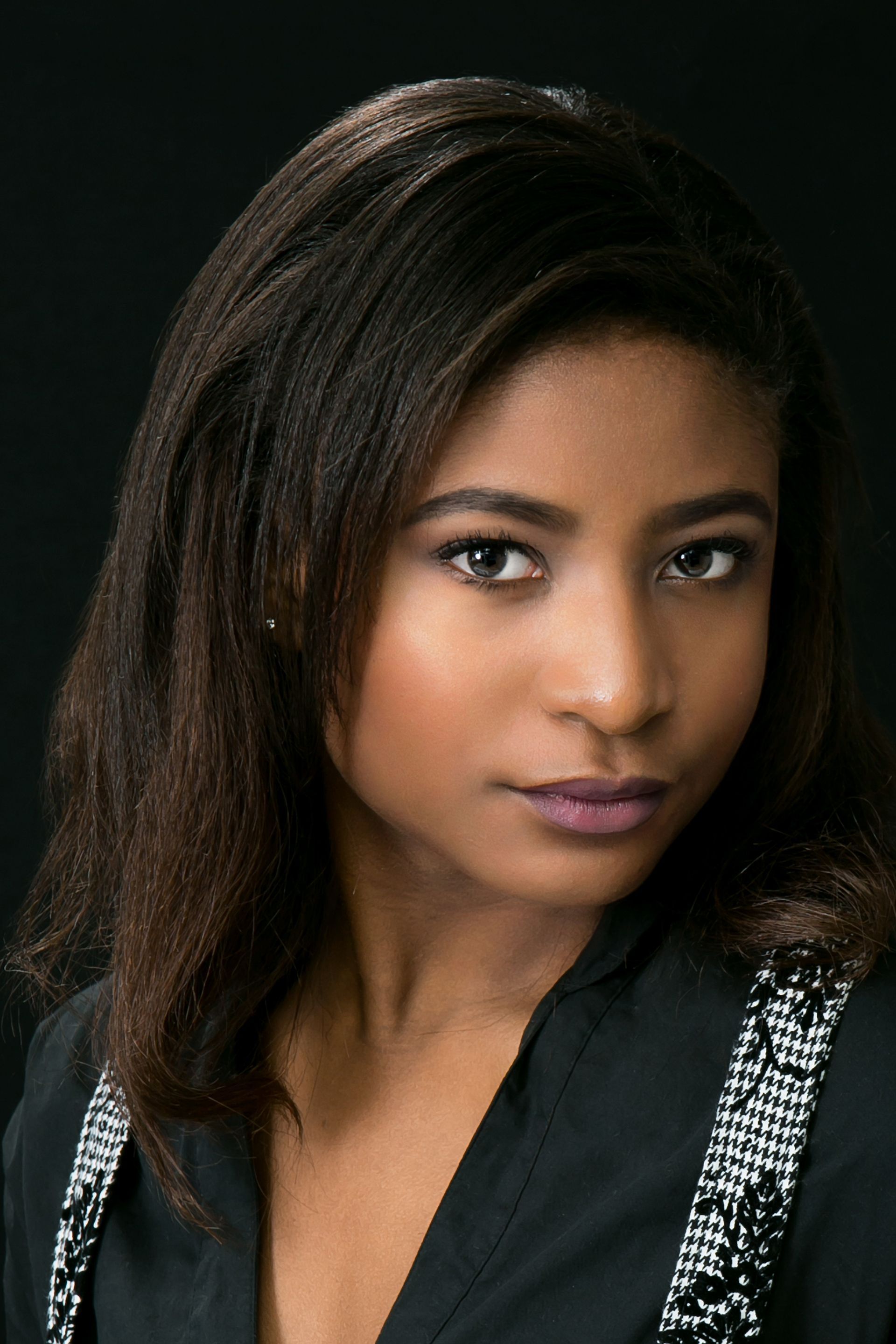 A close up of a woman 's face with a black background