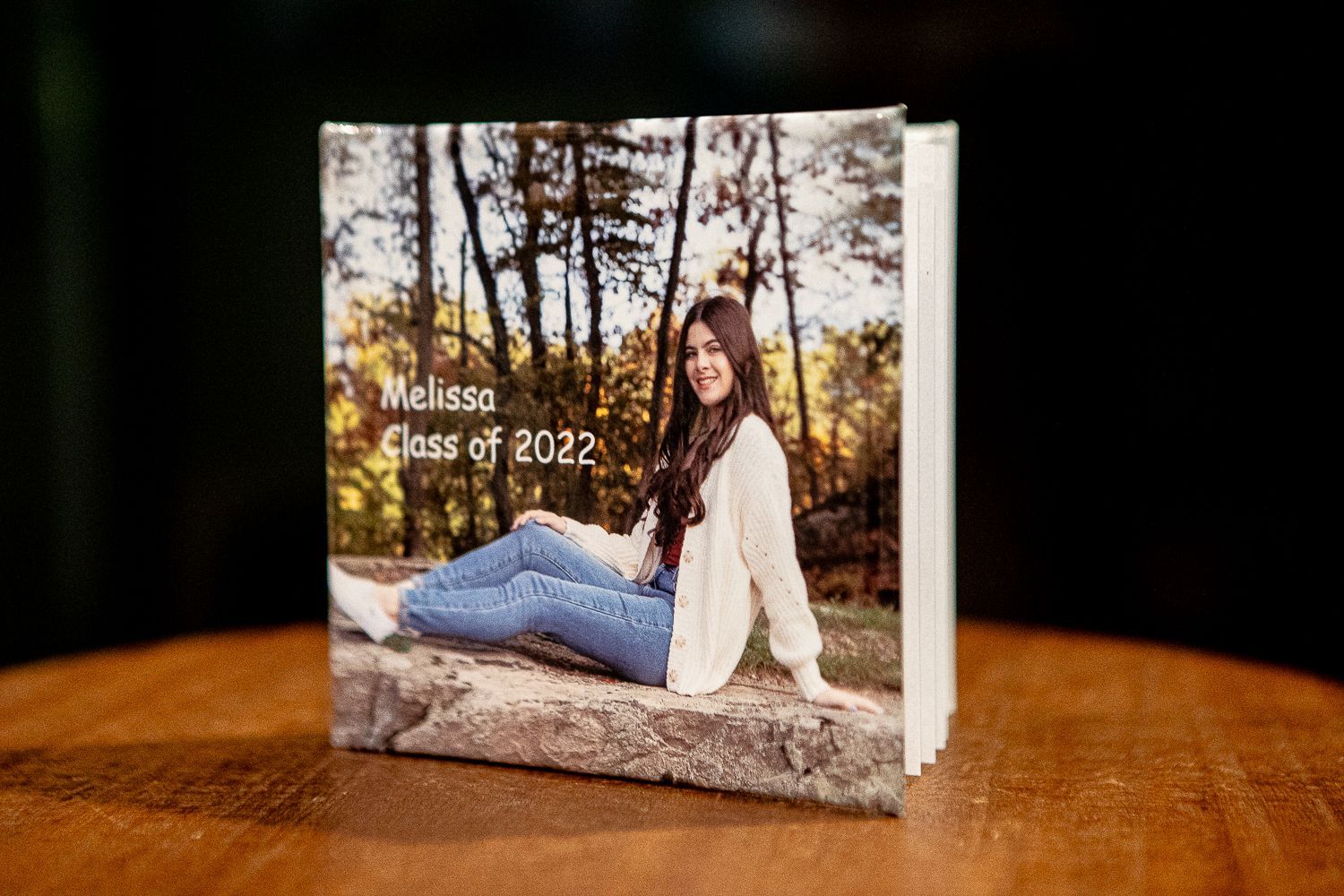 A graduation photo album with a smiling woman on the cover,