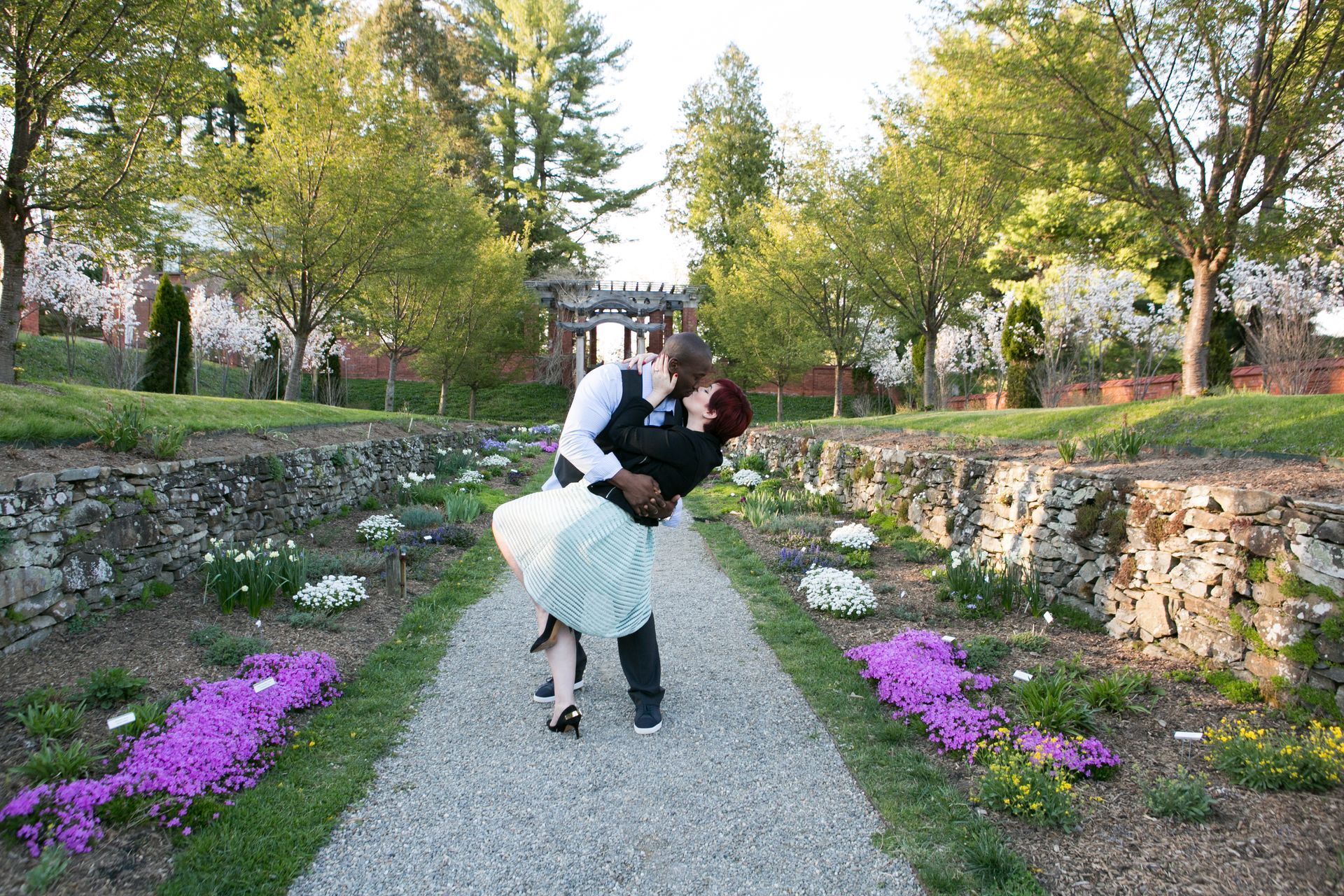 A man is holding a woman in his arms in a park.