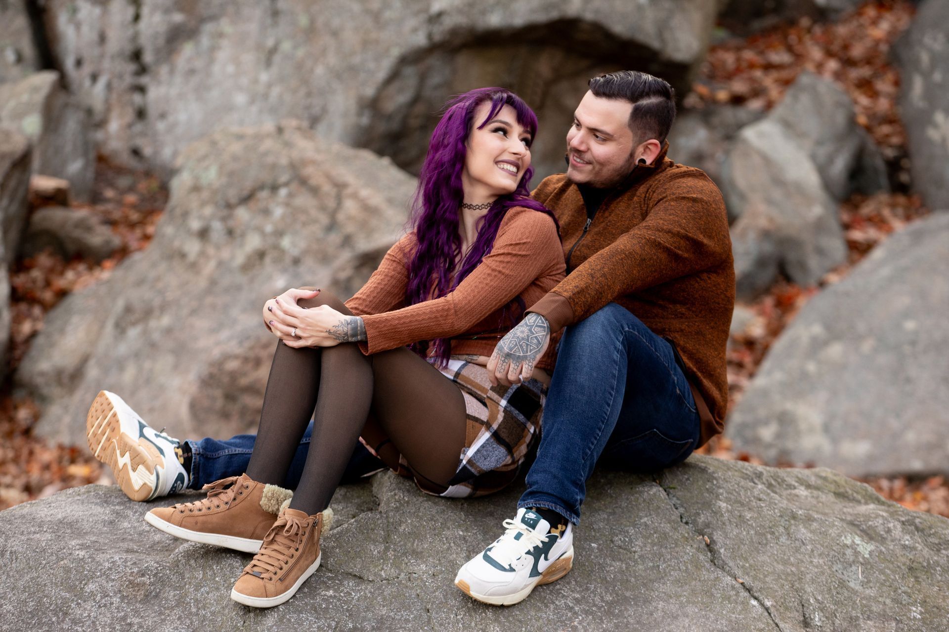 A man and a woman are sitting on a rock.