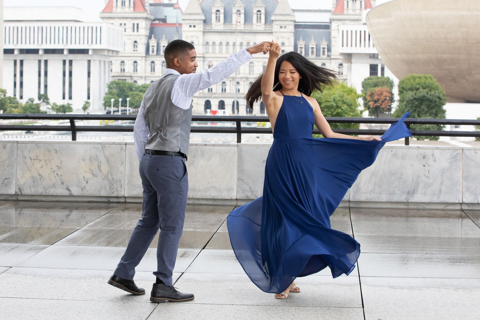 A man and a woman are dancing in front of a building.
