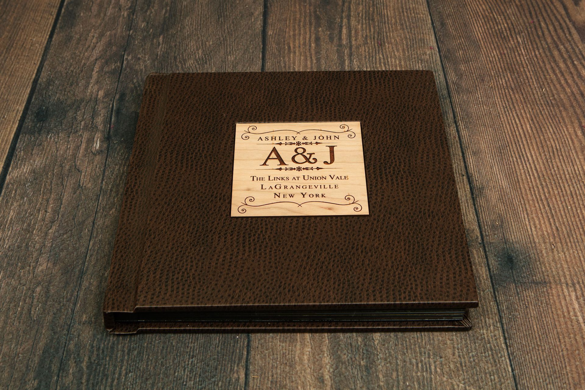 Brown leather photo album on a wooden surface.