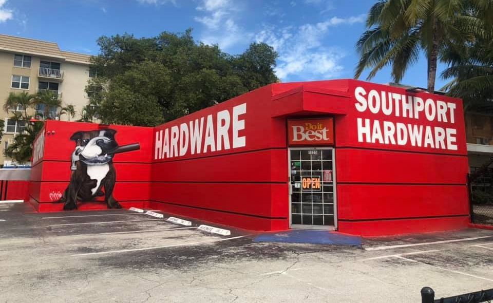 Red Southport Hardware building with a dog mural. 