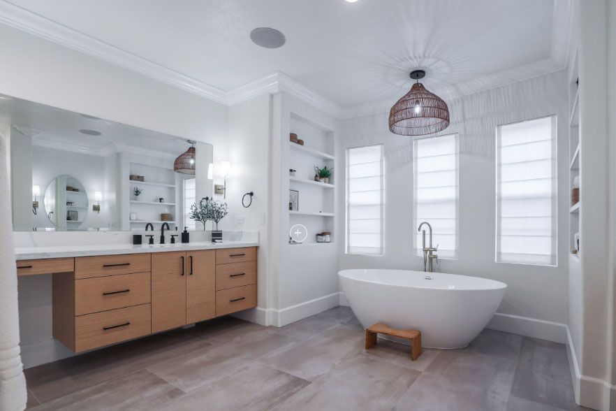 Bright modern bathroom with freestanding tub, double vanity, large mirror, and white tiled walls.