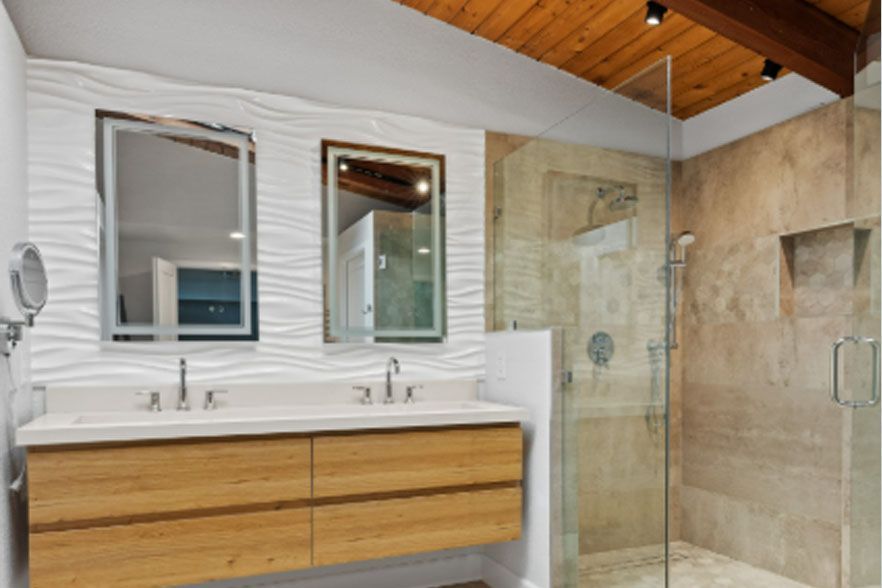 Modern bathroom with double vanity, mirrors, wood cabinet, and glass shower under a slanted wood ceiling