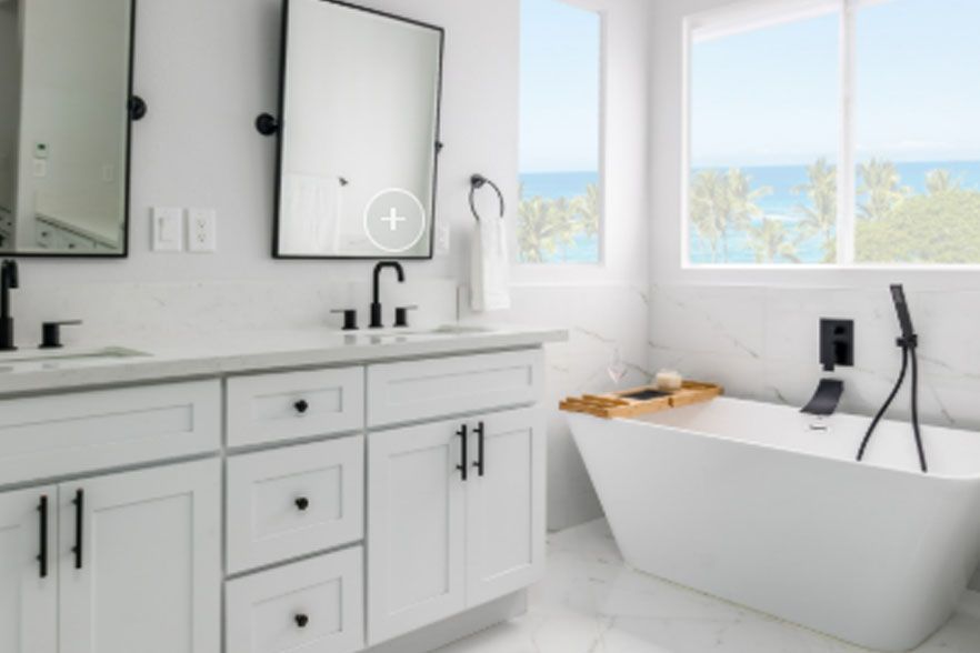 Bright white modern bathroom with double vanity, mirrors, and a freestanding tub by the window.
