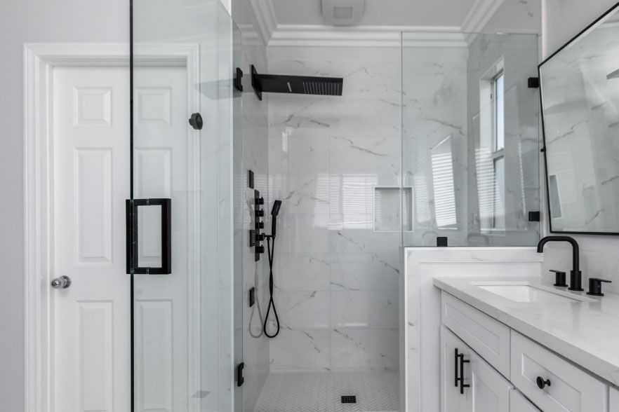 Modern white bathroom with glass walk-in shower and black fixtures