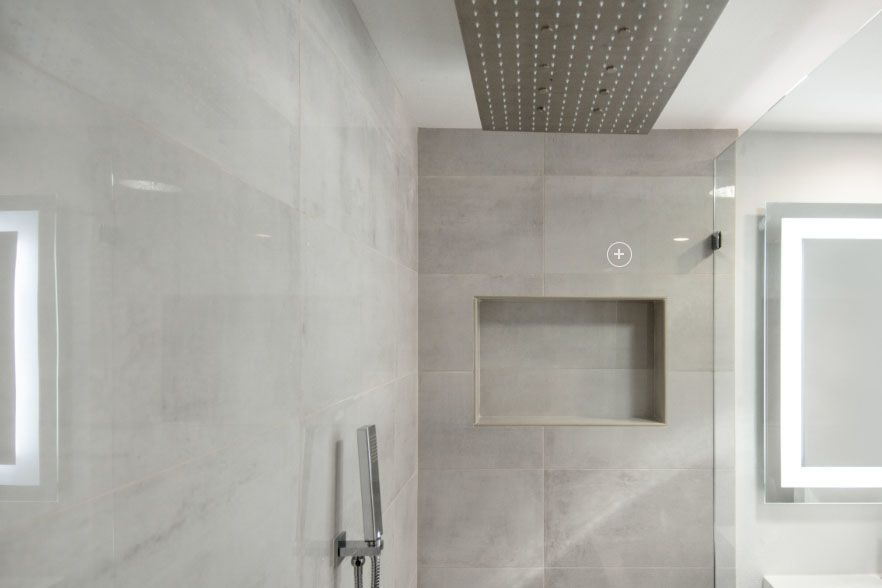 Modern gray tiled shower with built-in niche, rain showerhead, and two small windows on either side