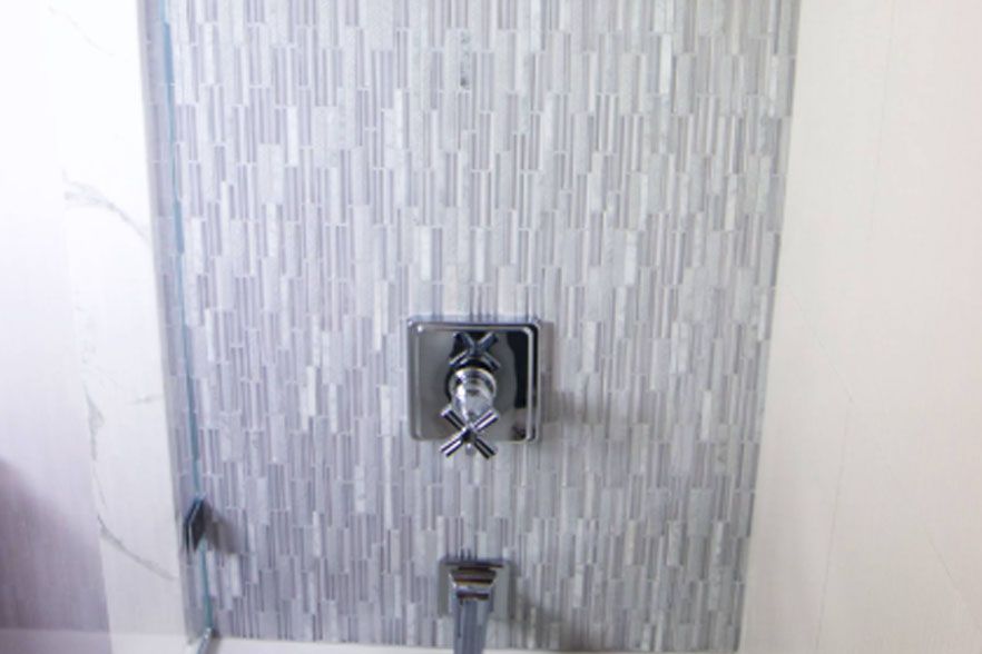 Chrome shower faucet on tiled bathroom wall