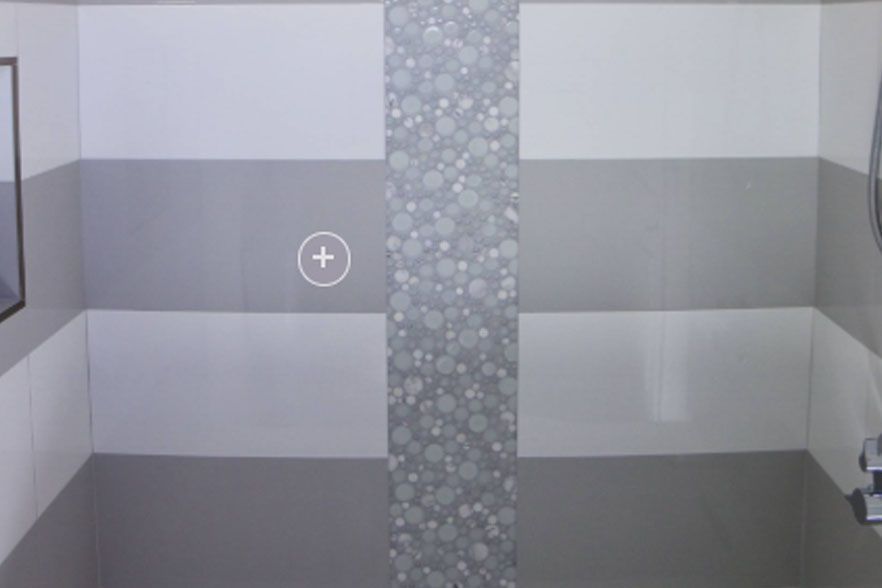 Empty tiled bathroom with gray and white walls and a patterned center column.