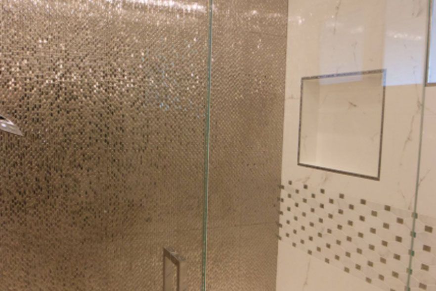 Textured glass shower enclosure with tiled wall and frosted panel, viewed inside a bathroom