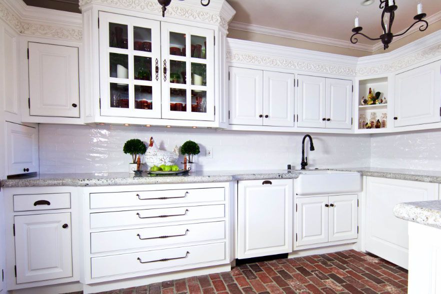White kitchen with cabinets, countertop, sink, and brick tile floor