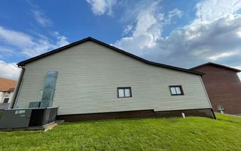 The back of a house with a hot tub in the backyard.