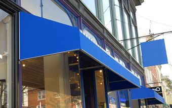 A blue awning is on the side of a building