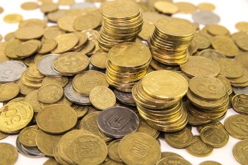 Stacks and scattered piles of gold coins on a white surface