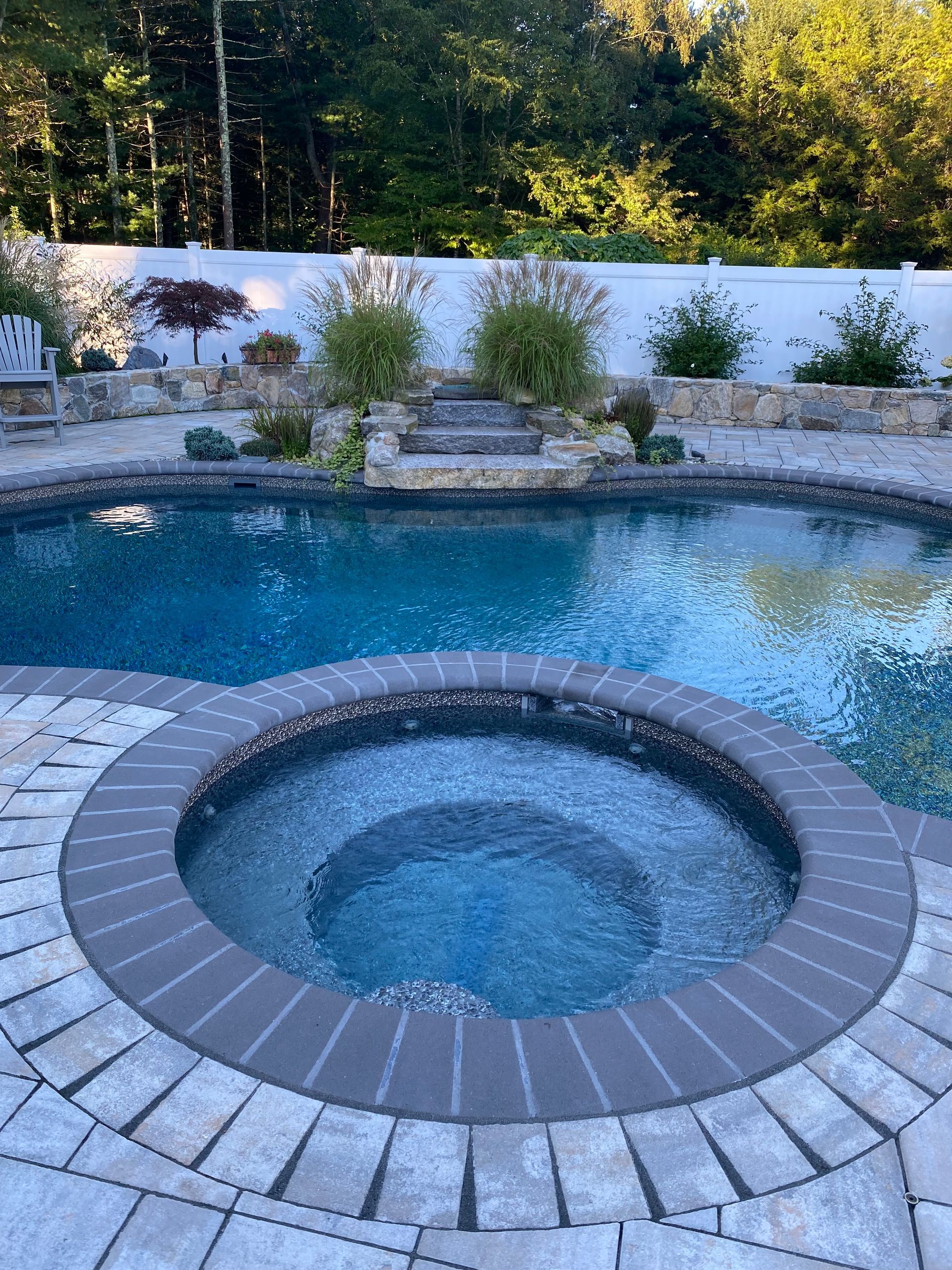 A large swimming pool with a hot tub in the middle of it.