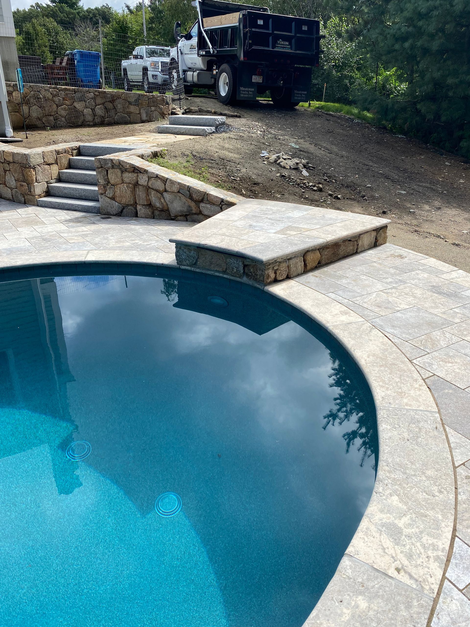 A dump truck is parked next to a swimming pool.