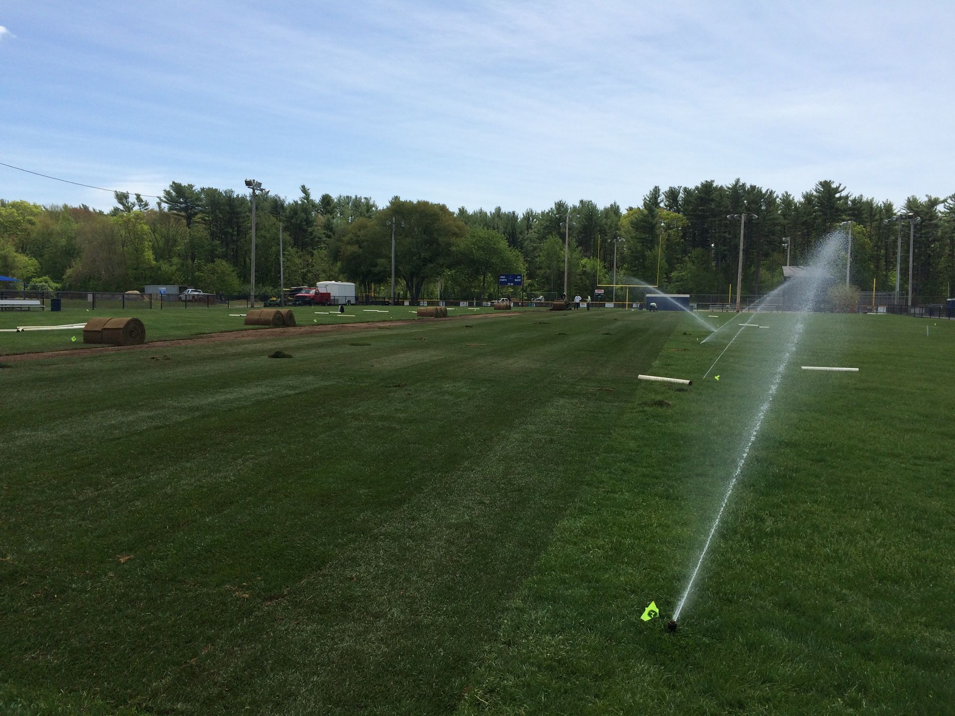 A sprinkler is spraying water on a lush green field.