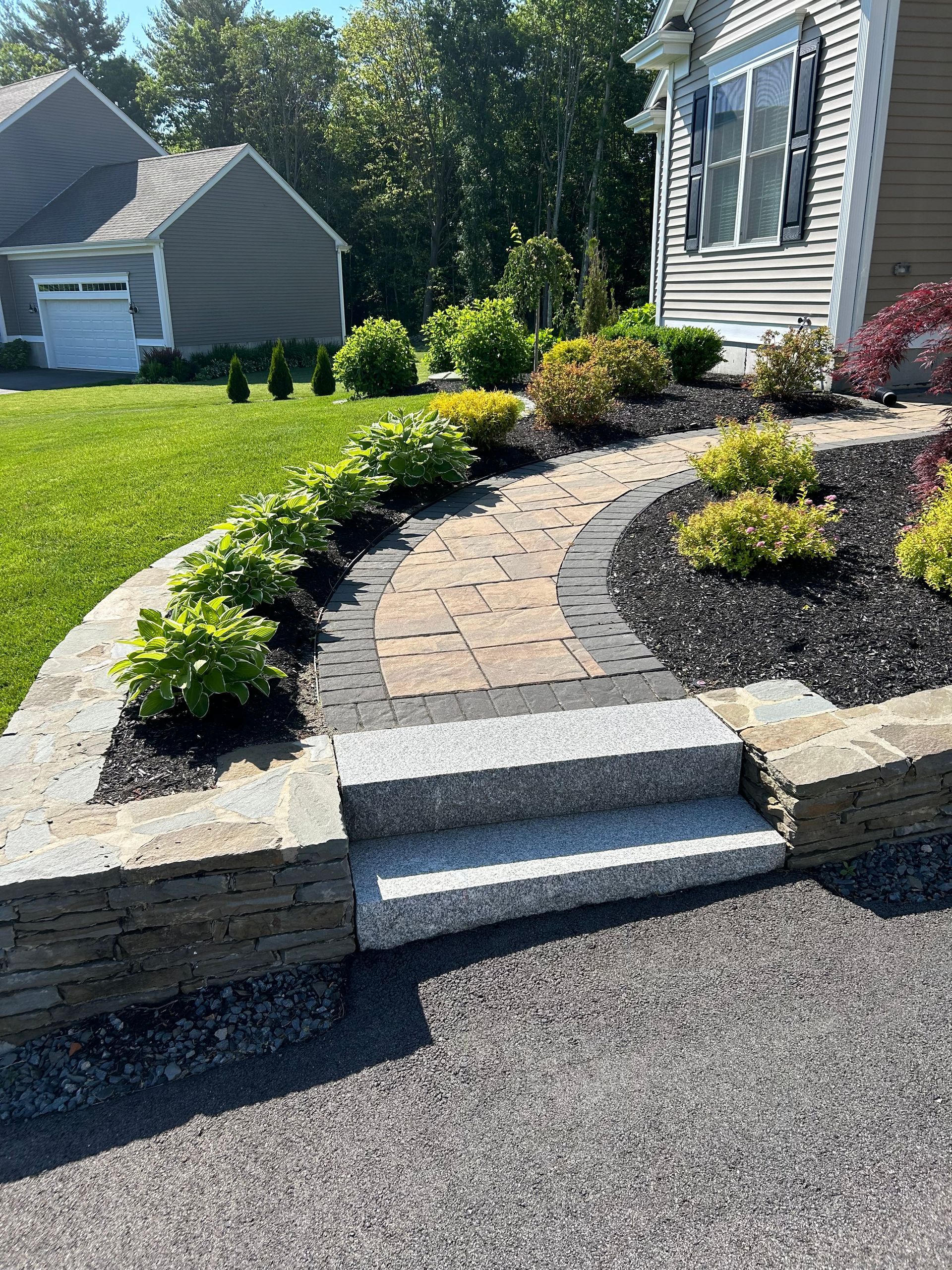 A brick walkway with steps leading up to a house.