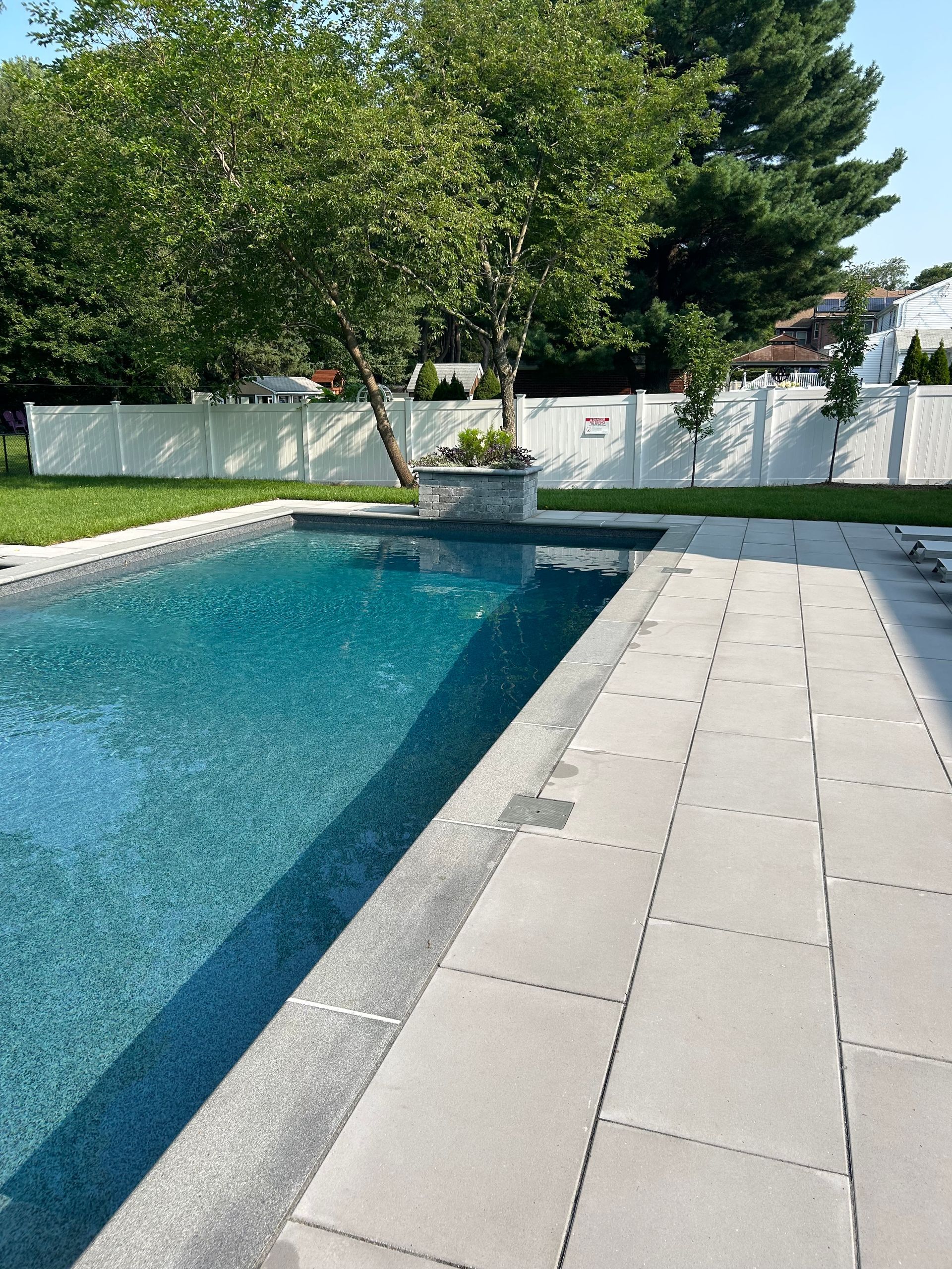 A large swimming pool with a tree in the middle of it