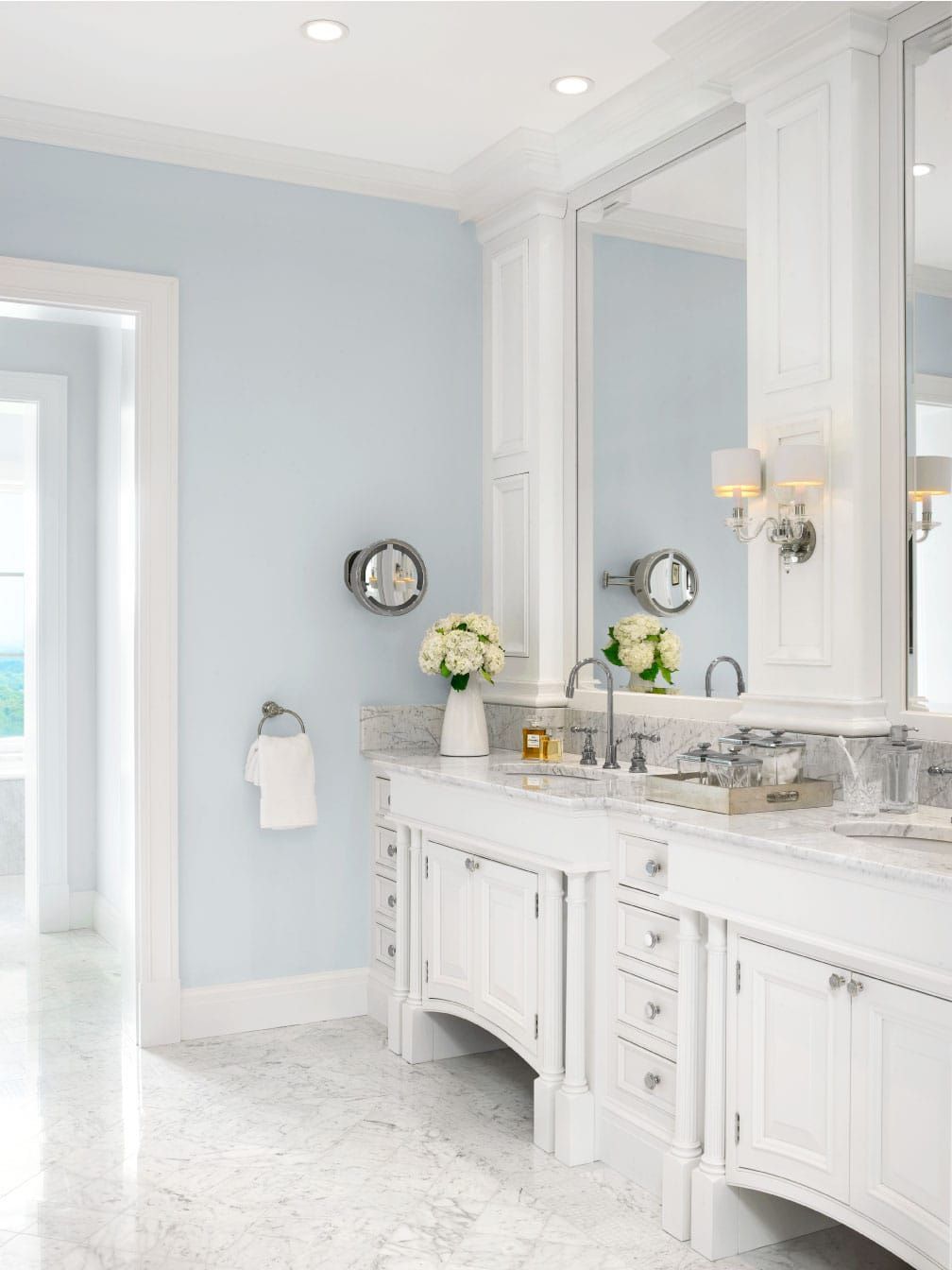 A bathroom with two sinks , a mirror and blue walls.