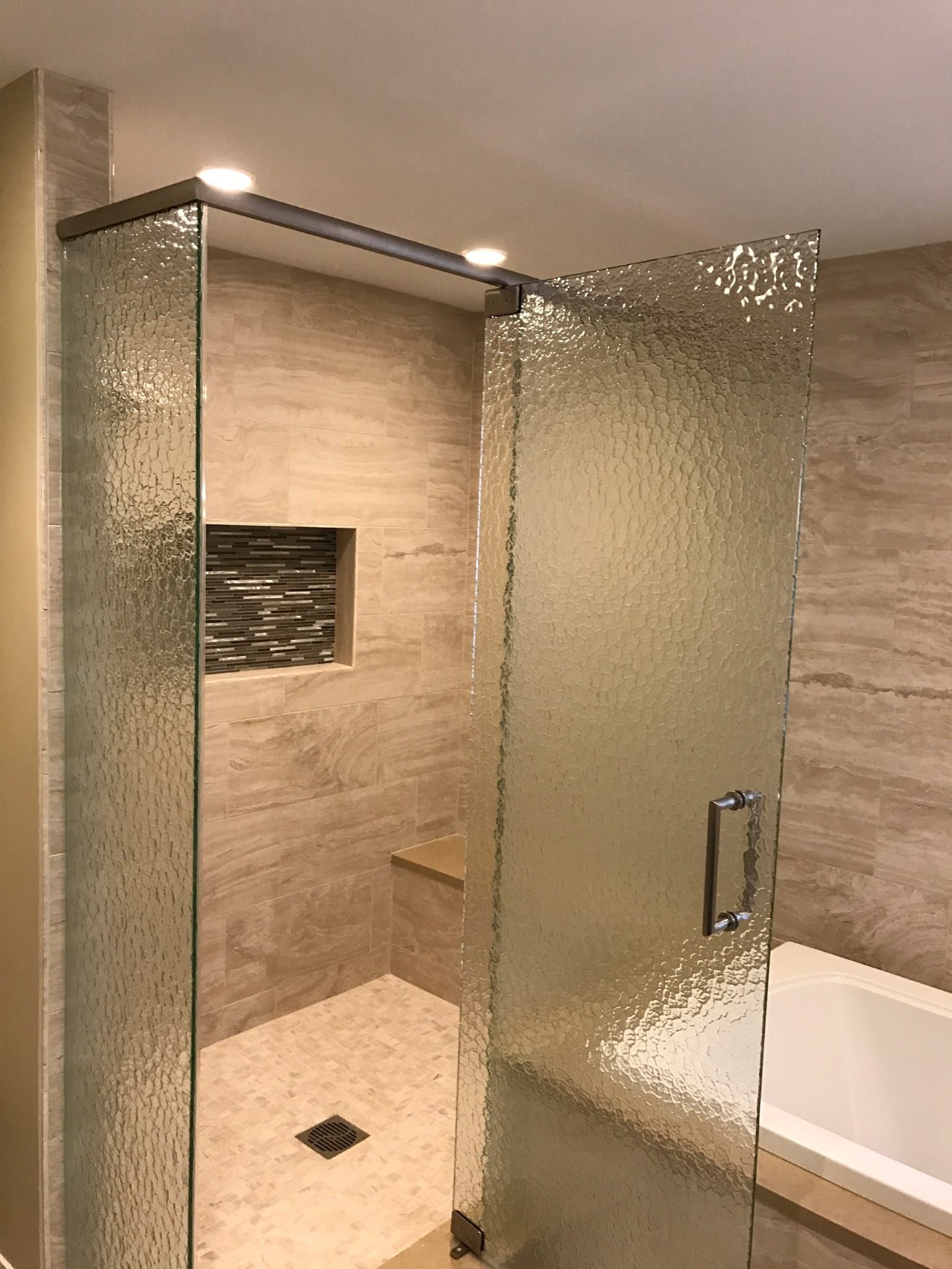 A bathroom with a walk in shower and a bathtub.