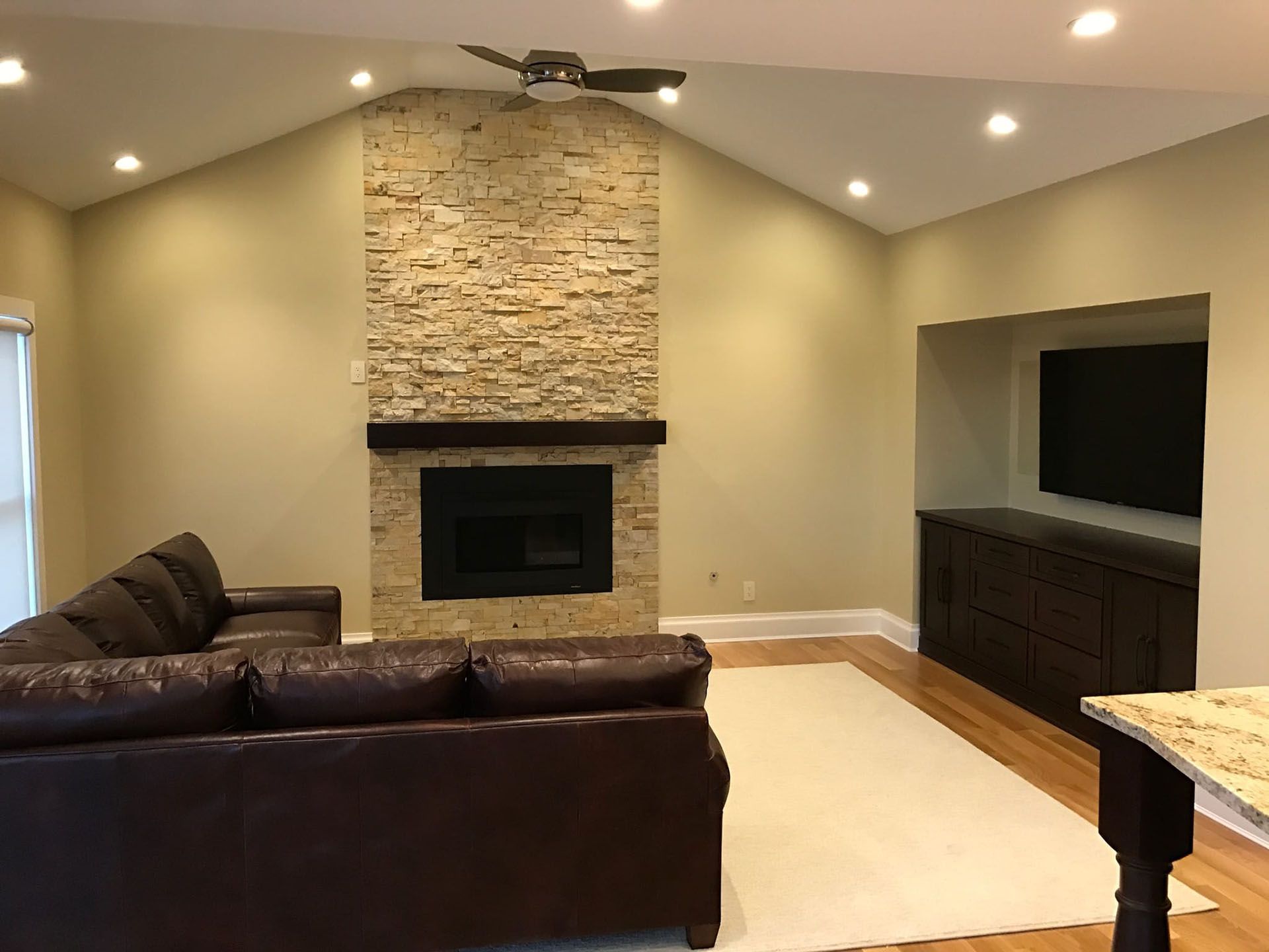 New interior remodeling project - a family room with a new fireplace, recessed lighting and ceiling fan