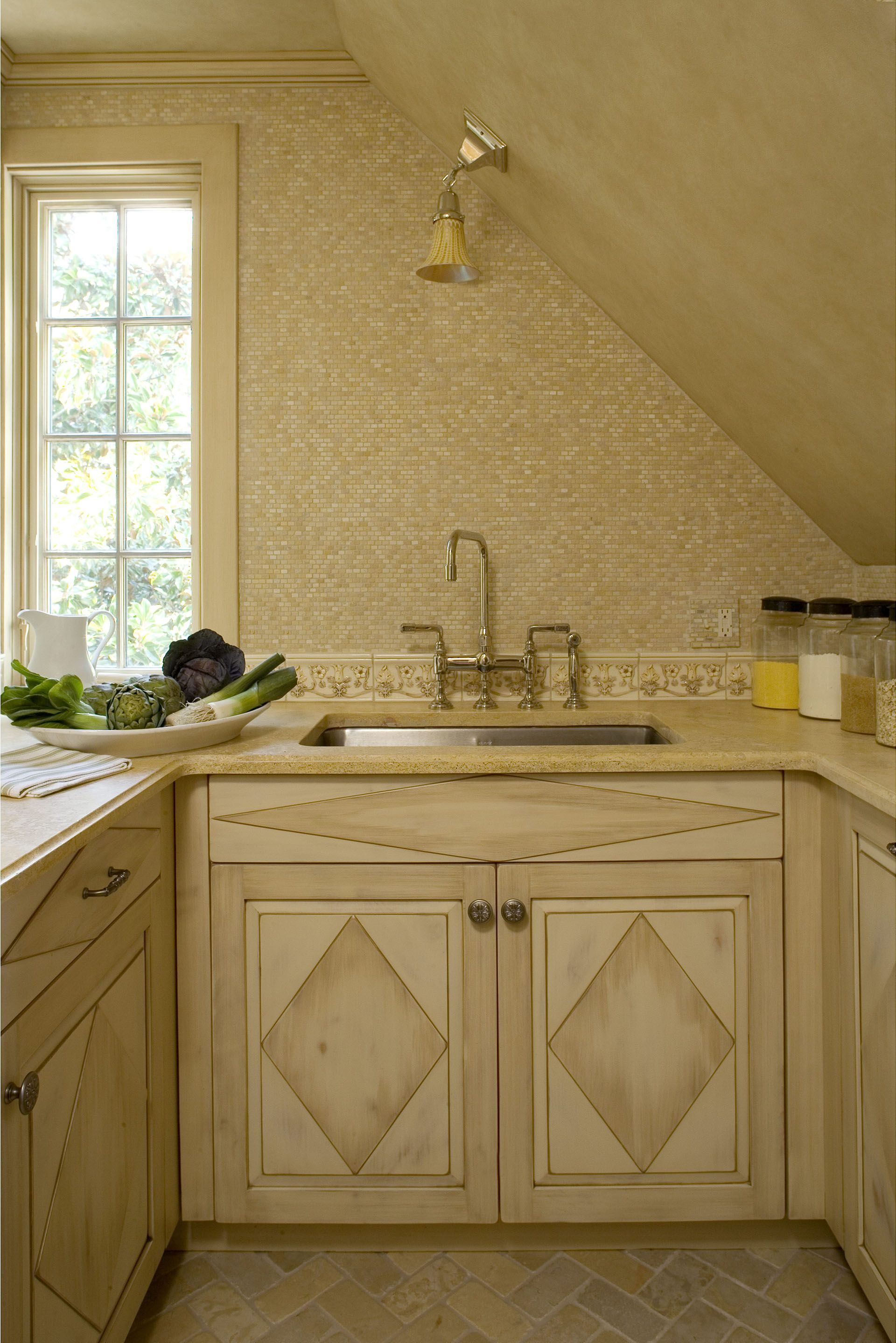 A kitchen with a sink , cabinets and a window