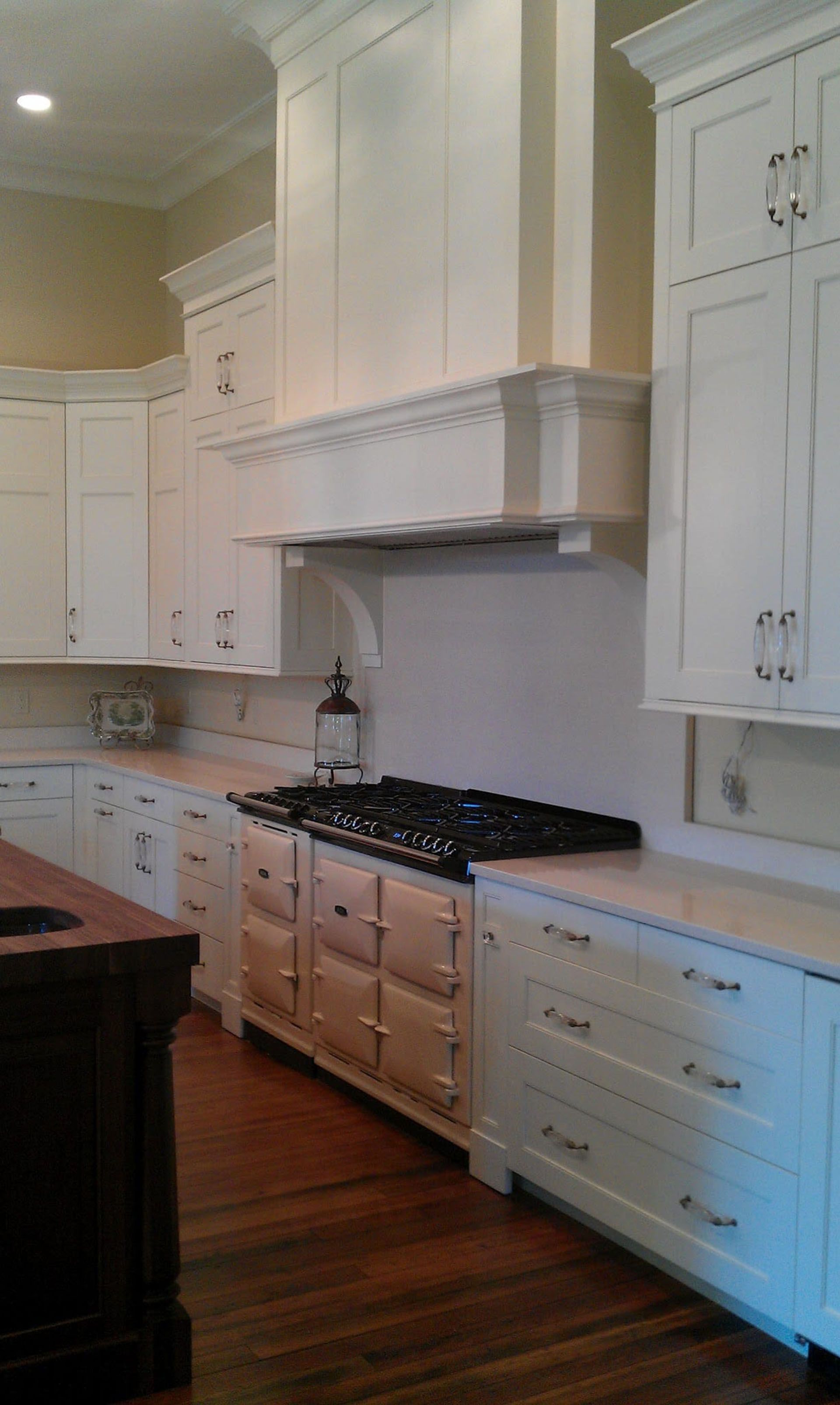 A kitchen with white cabinets and a stove top oven