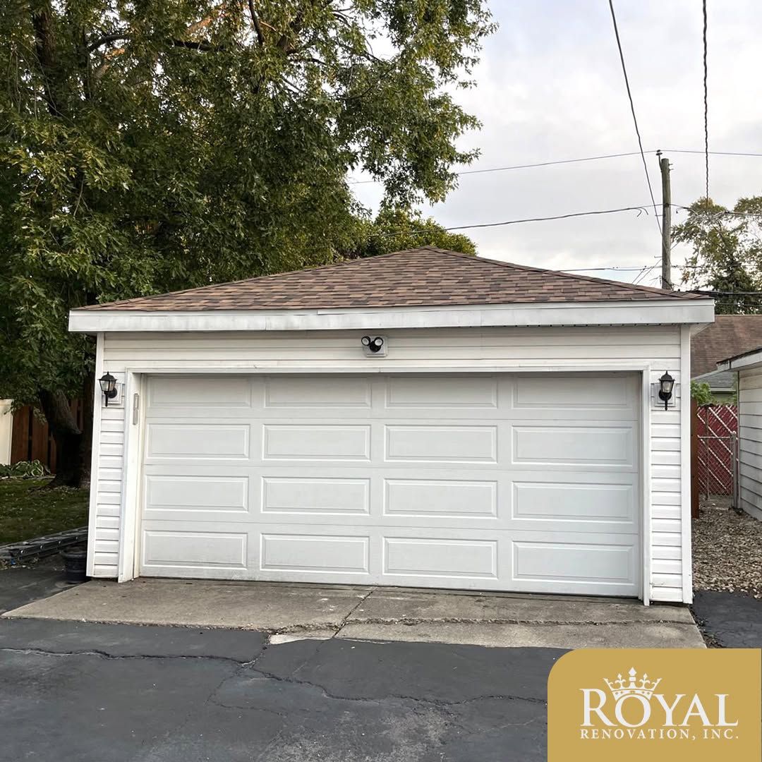 White two-car garage with a closed door and a shingled roof, seen from the street.