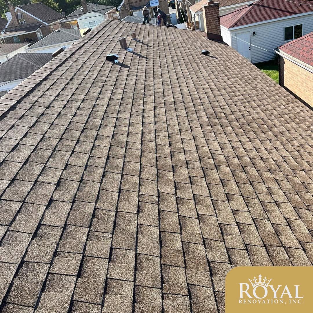 Roof covered with brown shingles, viewed from above with neighboring houses in the background