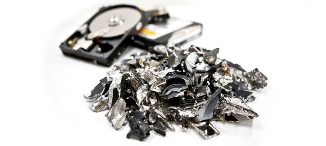 A pile of shredded metal next to a hard drive.