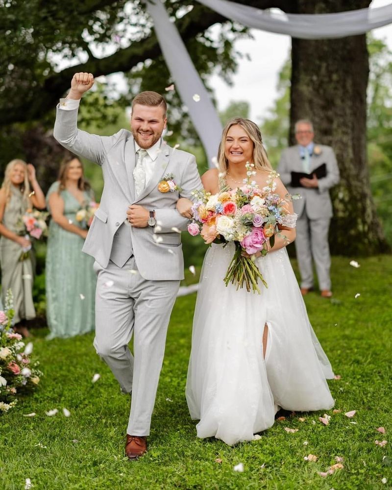 A bride and groom are walking down the aisle at their wedding.
