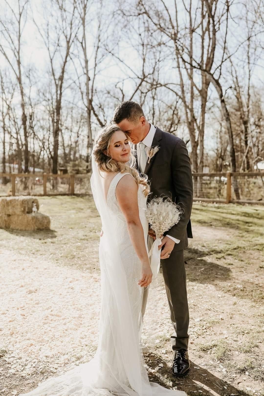 A bride and groom are posing for a picture on their wedding day.