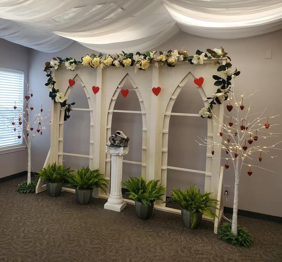 A room with a white arch decorated with flowers and hearts.
