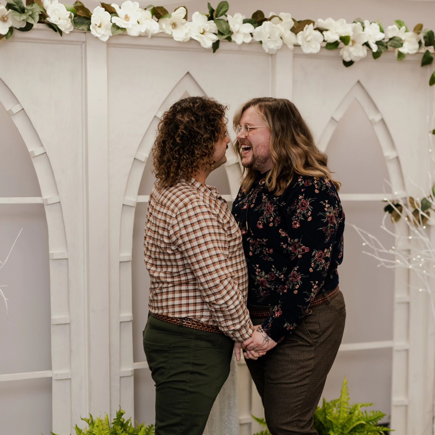 A man and a woman are holding hands and laughing.